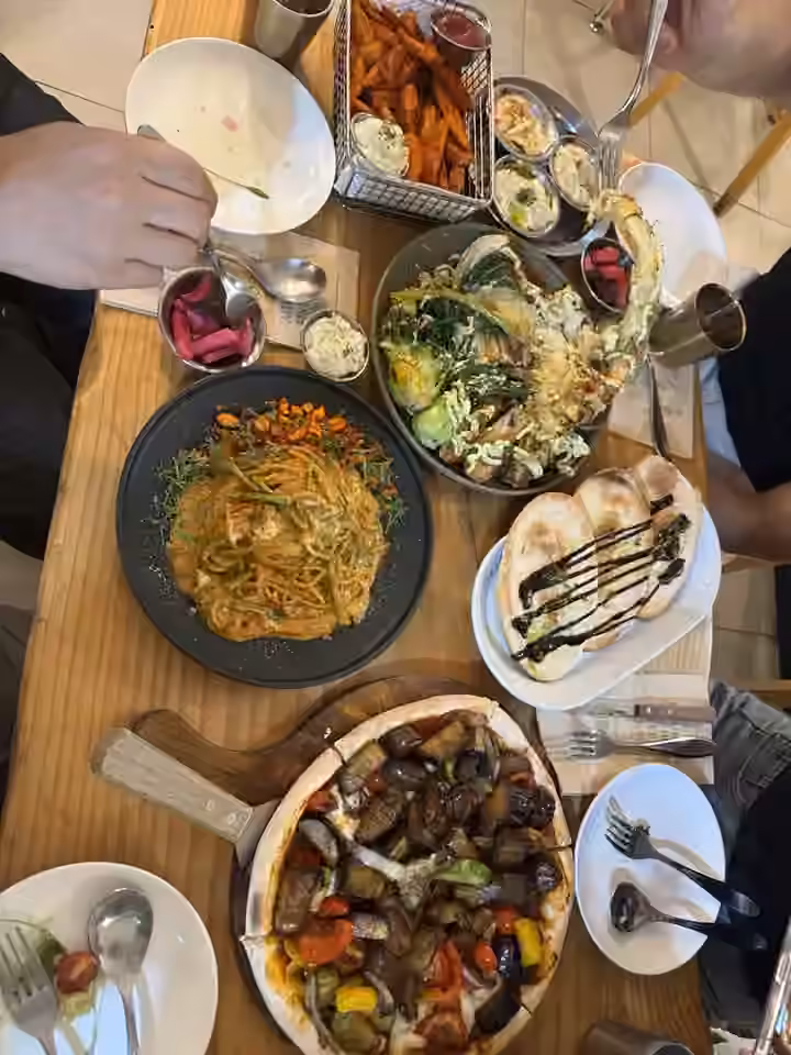 남미플랜트랩에서 촬영한 채소 피자, 파스타, 구운 채소와 납작빵의 식탁